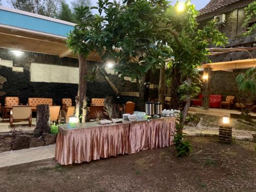 a table set up in a courtyard with a tree at Nuwono Tasya Syariah in Bandar Lampung