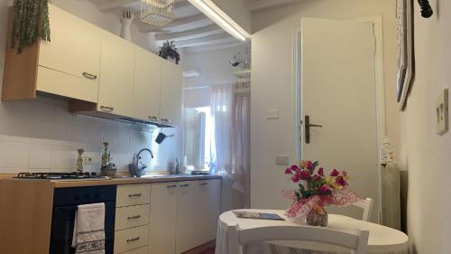 une cuisine avec un vase de fleurs sur une table dans l'établissement Appartamento incantevole nel centro di Arezzo, à Arezzo