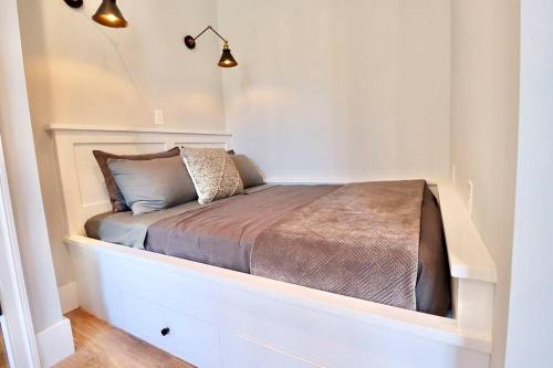 uma cama num quarto branco com um visor de cama em The Duke Suite at Prince Street Inn em Alexandria