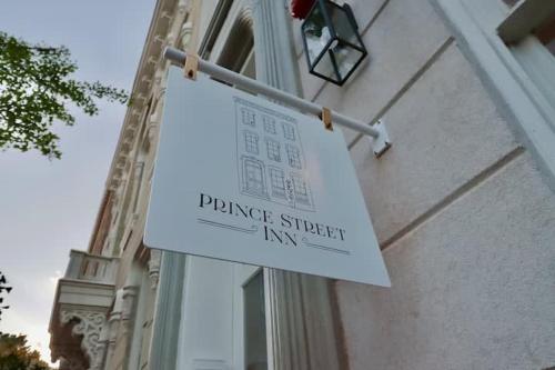 a sign hanging on the side of a building at The Queen Suite at Prince Street Inn in Alexandria