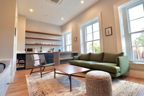 a living room with a green couch and a table at The Franklin Suite at Prince Street Inn in Alexandria
