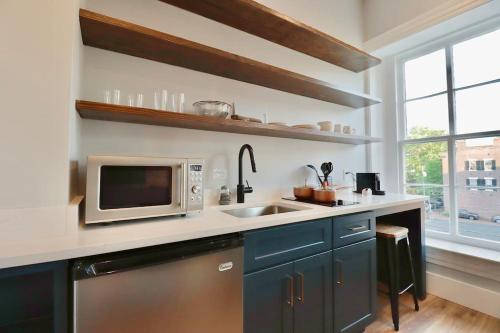 a kitchen with a sink and a microwave at The Franklin Suite at Prince Street Inn in Alexandria