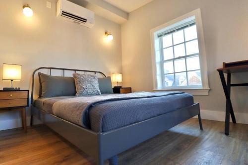 a bedroom with a bed and a window and a desk at The Fairfax Suite at Prince Street Inn in Alexandria