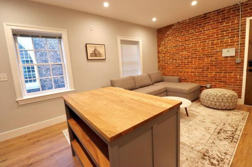 a living room with a couch and a brick wall at The Old Town Suite at Prince Street Inn in Alexandria