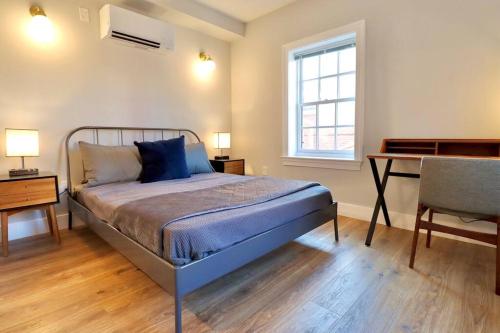 1 dormitorio con cama, escritorio y silla en The Old Town Suite at Prince Street Inn, en Alexandria