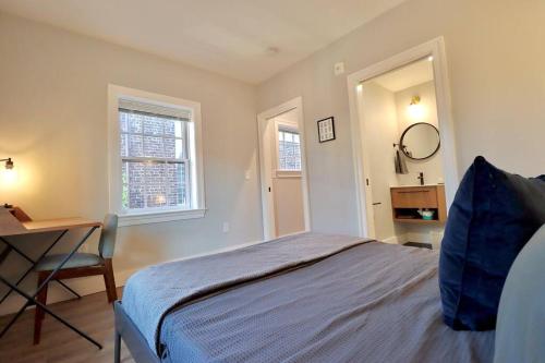 a bedroom with a bed and a desk and a window at The Old Town Suite at Prince Street Inn in Alexandria