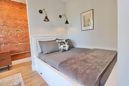 una cama en una habitación con una pared de ladrillo en 9 Suites at Prince Street Inn, en Alexandria