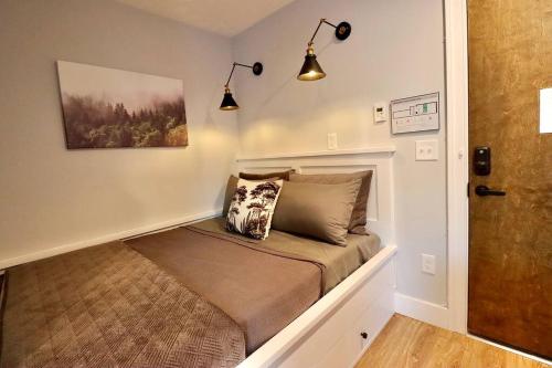 a small bed in a room with two lights at The Jefferson Suite at Prince Street Inn in Alexandria