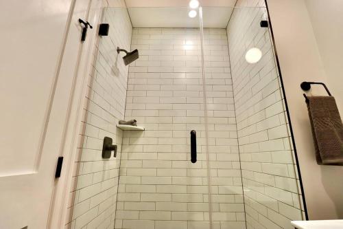 a bathroom with a shower with white tiles at The Jefferson Suite at Prince Street Inn in Alexandria