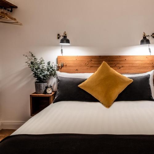 a bedroom with a large bed with a wooden headboard at Black Cat in Galway