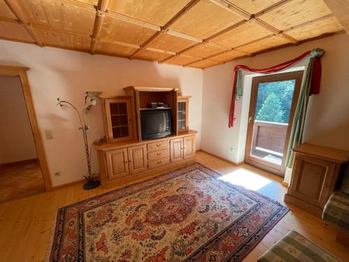 ein Wohnzimmer mit einem TV und einem Teppich in der Unterkunft Alpengasthof Wegscheid in Kelchsau
