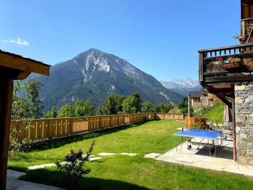 a backyard with a table and a mountain in the background at Chalet des Trappeurs Coeur Vanoise 15 persons in Champagny-en-Vanoise