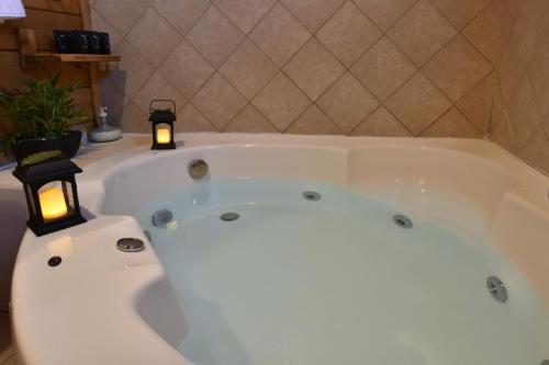 a bath tub with two candles in a bathroom at בקתות בית מאיר אבירים - זמן בריאה in Abirim