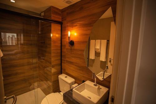 a bathroom with a toilet and a sink and a shower at Manaíra Apart Hotel por Carpediem in Tambaú