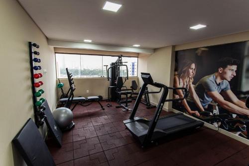 a man and woman in a gym with a simulator at Manaíra Apart Hotel por Carpediem in Tambaú