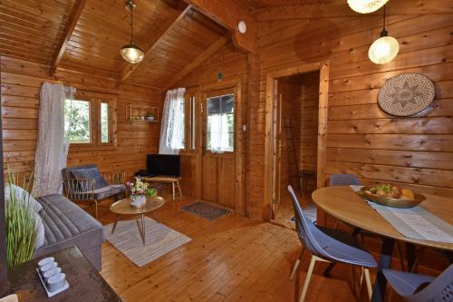 a living room of a log cabin with a table and chairs at בקתות בית מאיר אבירים - זמן בריאה in Abirim