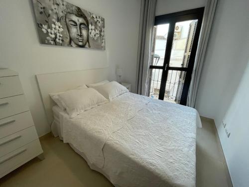 a bedroom with a white bed and a window at Royal Suites Estepona by Croma in Estepona
