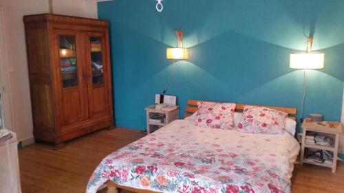 - une chambre avec un lit et un mur bleu dans l'établissement Menhir douarnenez, à Douarnenez