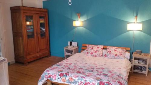 een slaapkamer met een bed en een blauwe muur bij Menhir douarnenez in Douarnenez