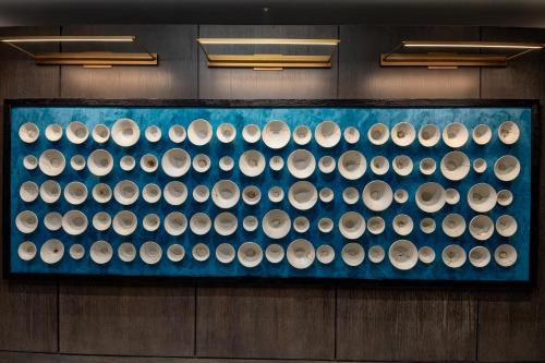 a display case filled with bowls on a wall at Hyatt Centric Charlotte SouthPark in Charlotte