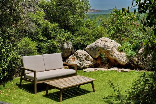 a chair and a coffee table in the grass at בקתות בית מאיר אבירים - זמן בריאה in Abirim