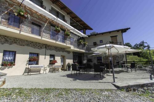 a building with tables and chairs and an umbrella at Ca Montiglio in Quagliuzzo