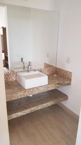 a bathroom with a white sink and a mirror at Chalés Capitólio in Capitólio