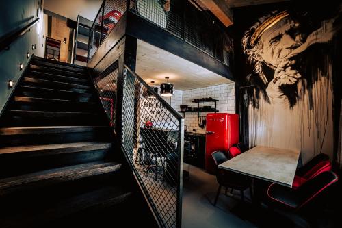 a room with a table and a staircase with a mural at Boutique Apartments OLD SCHOOL in Söll