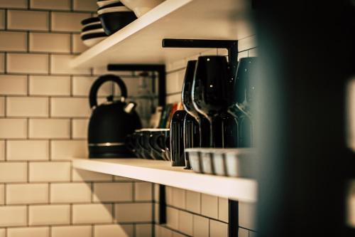 a shelf in a kitchen filled with pots and pans at Boutique Apartments OLD SCHOOL in Söll