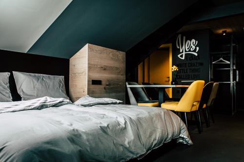a bedroom with a bed and a table and chairs at Boutique Apartments OLD SCHOOL in Söll