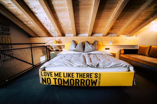 a bedroom with a bed with a sign on it at Boutique Apartments OLD SCHOOL in Söll