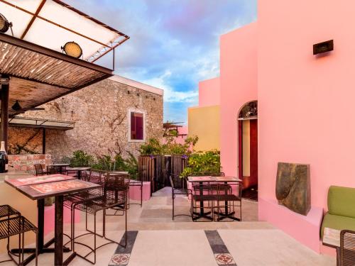 a patio area with tables, chairs and umbrellas at Rosas & Xocolate Boutique Hotel+Spa in Mérida