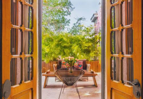 an open door to a patio with a table and a couch at Rosas & Xocolate Boutique Hotel and Spa Merida, a Member of Design Hotels in Mérida