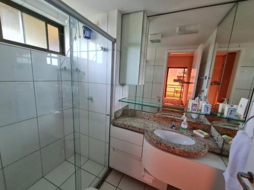a bathroom with a sink and a shower and a mirror at Apartamento mobiliado Beach Place Porto das Dunas in Prainha