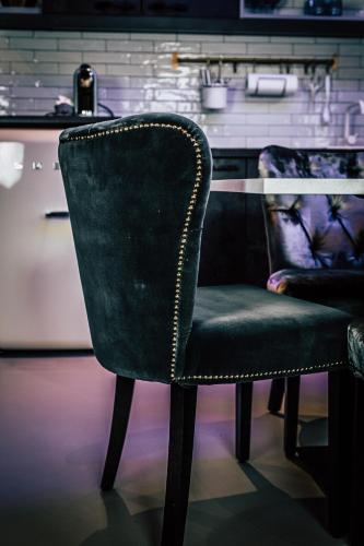 a green chair sitting next to a table at Boutique Apartments OLD SCHOOL in Söll