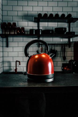 a red tea kettle sitting on top of a counter at Boutique Apartments OLD SCHOOL in Söll