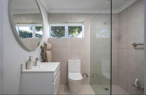 a bathroom with a toilet and a sink and a shower at 29@Whale Rock Estate in Hermanus