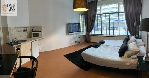 een slaapkamer met een bed en een groot raam bij El Sol Zandvoort in Zandvoort