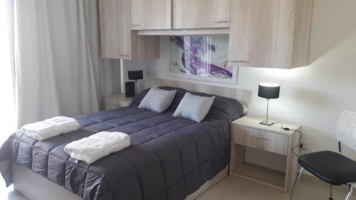 a bedroom with a blue bed with a desk and a chair at Plaza 376 in Chivilcoy