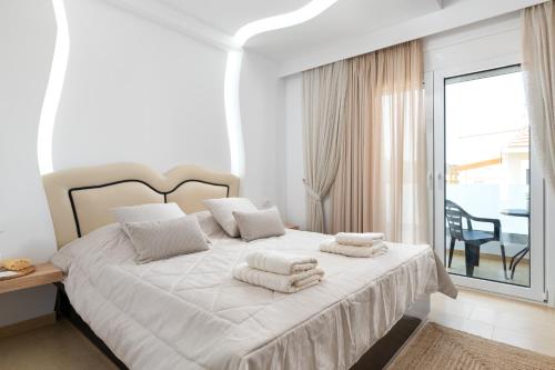 um quarto branco com uma cama com toalhas em White House Kokas Luxury Apartments em Kremasti