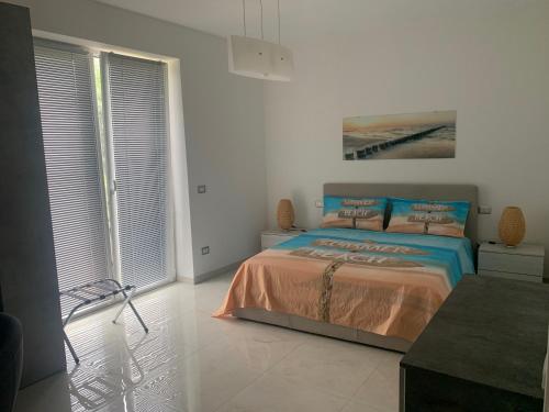 een slaapkamer met een bed in een witte kamer bij Affittacamere EROI in Verbania