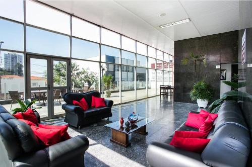 a living room with black leather couches and red pillows at Hotel InterAmericana in Americana