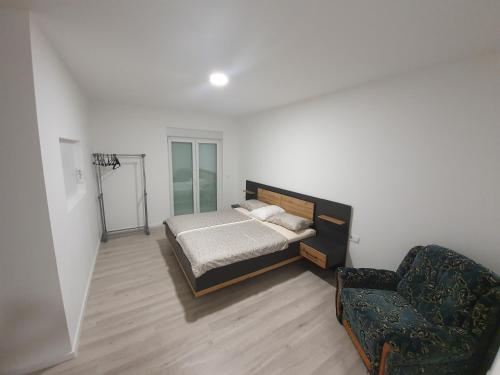 a bedroom with a bed and a chair at Apartman Libertas in Posušje