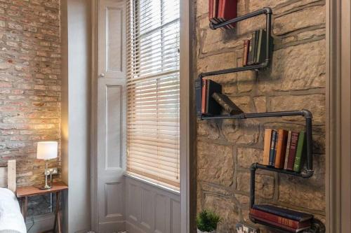 Cette chambre est dotée d'un mur en pierre, d'une fenêtre et de livres. dans l'établissement The Oldgate, à Morpeth