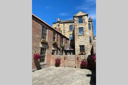 a large stone building with a courtyard in front at The Oldgate in Morpeth