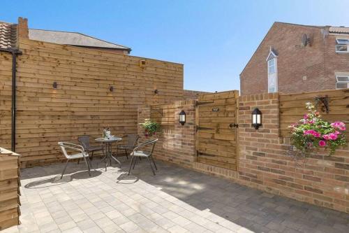 a patio with a fence and a table and chairs at The Oldgate in Morpeth