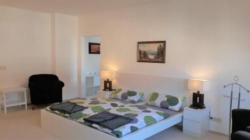 biała sypialnia z łóżkiem i 2 lampami w obiekcie Penthouse Wolkenstein großzügige Maisonette auf 155 qm mit Whirlpool, Klima & Kamin w mieście Senftenberg