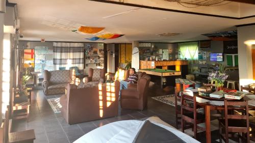 a man sitting on a couch in a living room at Mile Crunchers Backpackers & Hostelling in Mossel Bay