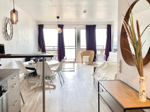 eine Küche und ein Wohnzimmer mit einem Tisch und Stühlen in der Unterkunft Studio mit Panorama-Meerblick und direkter Strandlage in Scharbeutz in Scharbeutz