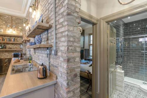 a bathroom with a sink and a stone wall at The Collingwood in Morpeth